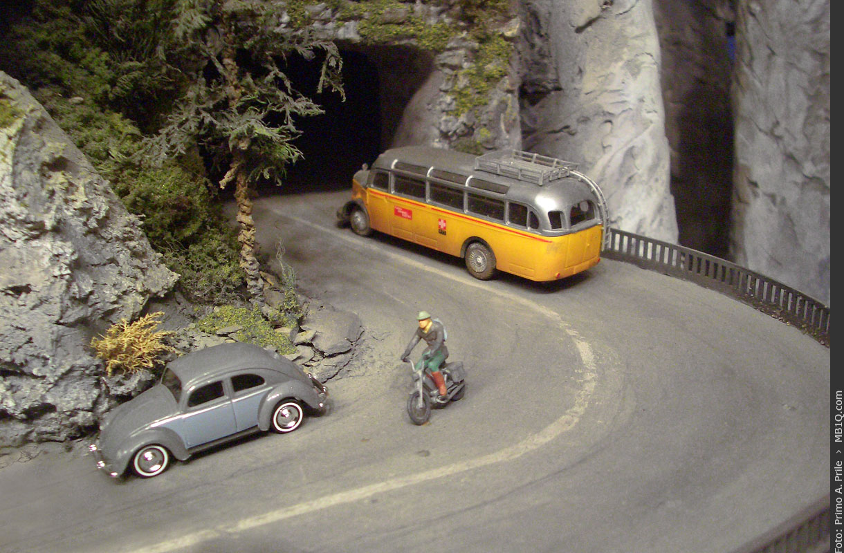 VW Käfer und PTT-Postauto auf einer Gebirgsstrasse